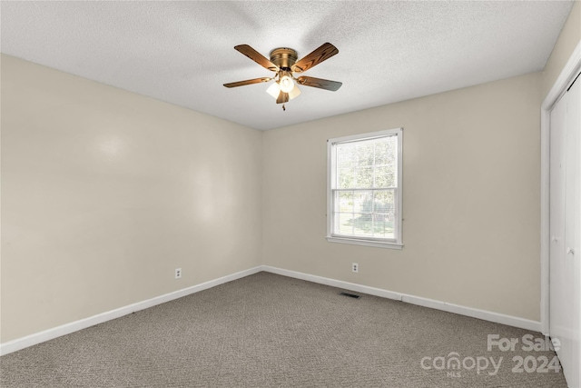 unfurnished bedroom with a closet, ceiling fan, a textured ceiling, and carpet floors