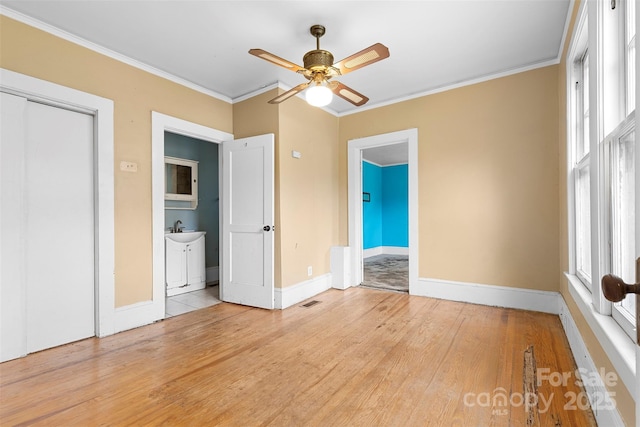 unfurnished bedroom with ensuite bath, ceiling fan, light hardwood / wood-style floors, and ornamental molding