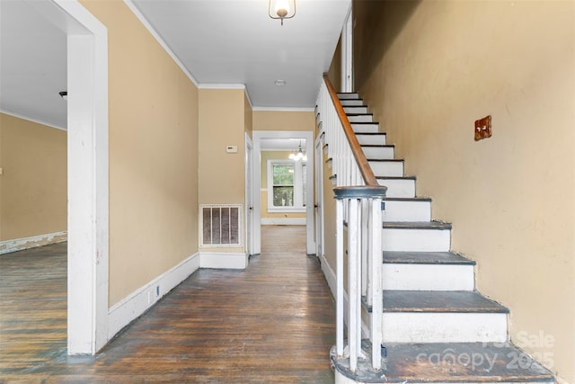 stairs with hardwood / wood-style floors and crown molding