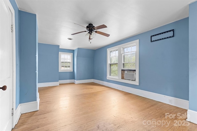 spare room featuring ceiling fan, cooling unit, and light hardwood / wood-style flooring