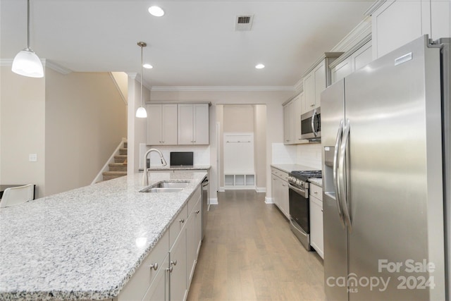 kitchen with visible vents, appliances with stainless steel finishes, wood finished floors, crown molding, and a sink