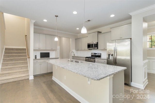 kitchen featuring wood finished floors, a sink, visible vents, appliances with stainless steel finishes, and an island with sink