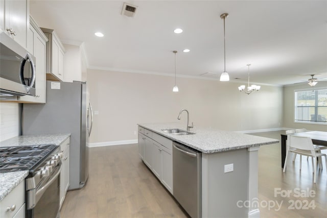 kitchen with a center island with sink, decorative backsplash, appliances with stainless steel finishes, ornamental molding, and a sink