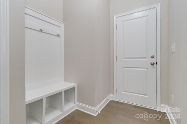 mudroom with dark wood finished floors and baseboards