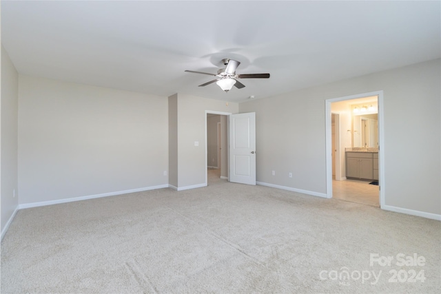 unfurnished bedroom featuring ceiling fan, carpet floors, ensuite bath, and baseboards