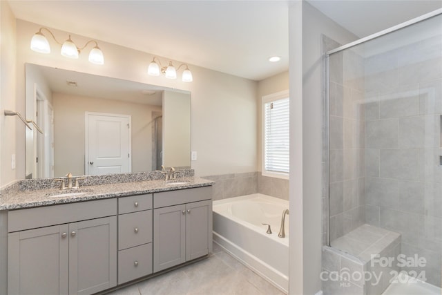 full bath with double vanity, a stall shower, a sink, tile patterned flooring, and a bath