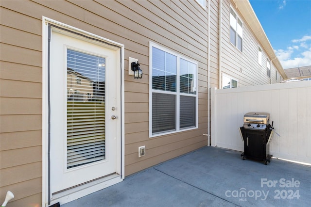 entrance to property featuring a patio area and fence