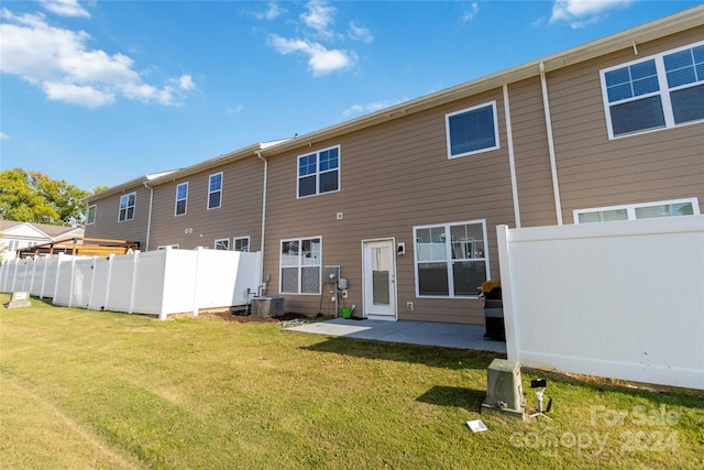 back of house with a patio, a lawn, fence, and central air condition unit