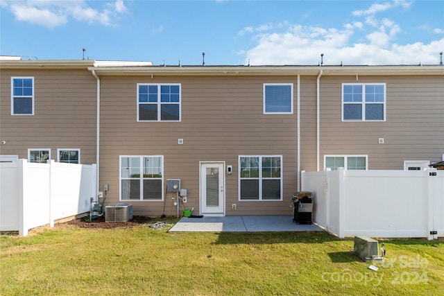 rear view of house with a patio area, a fenced backyard, and a lawn