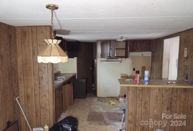 kitchen with kitchen peninsula and wooden walls