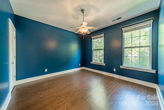 spare room with dark hardwood / wood-style flooring and ceiling fan