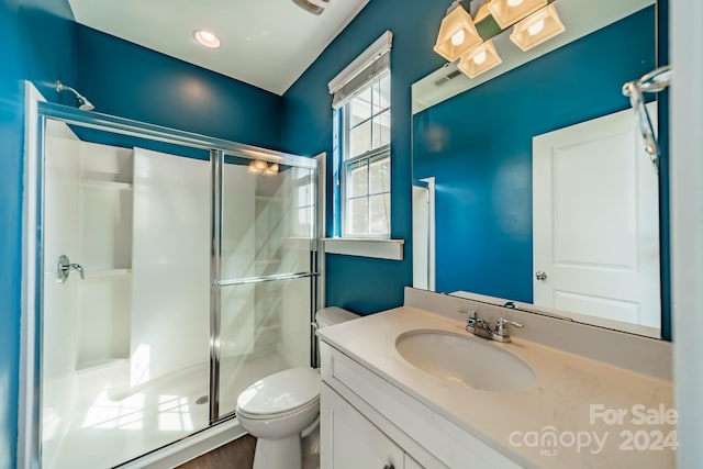 bathroom with a shower with shower door, hardwood / wood-style floors, toilet, and vanity