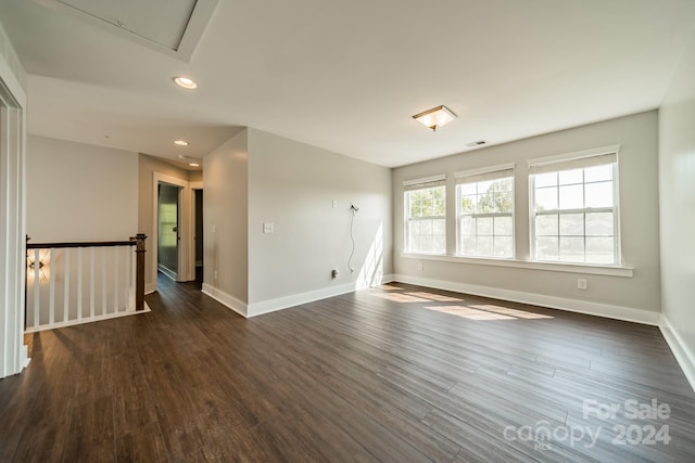 empty room with dark hardwood / wood-style flooring