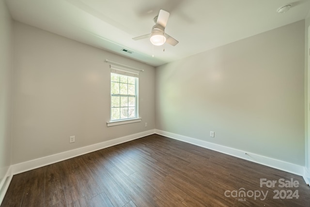 spare room featuring dark wood-type flooring and ceiling fan