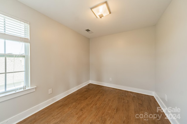 spare room with wood-type flooring and a wealth of natural light