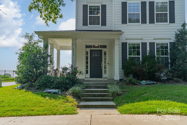 doorway to property with a lawn