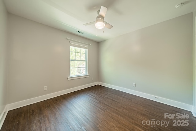 empty room with dark hardwood / wood-style flooring and ceiling fan