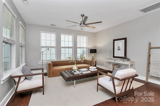 living room featuring ceiling fan and dark hardwood / wood-style flooring