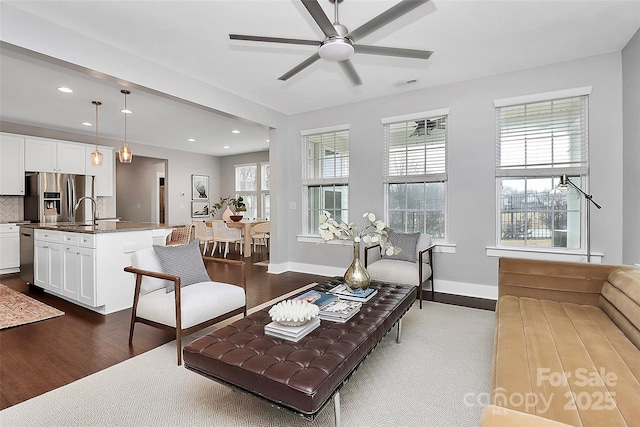 living room with ceiling fan and dark hardwood / wood-style floors