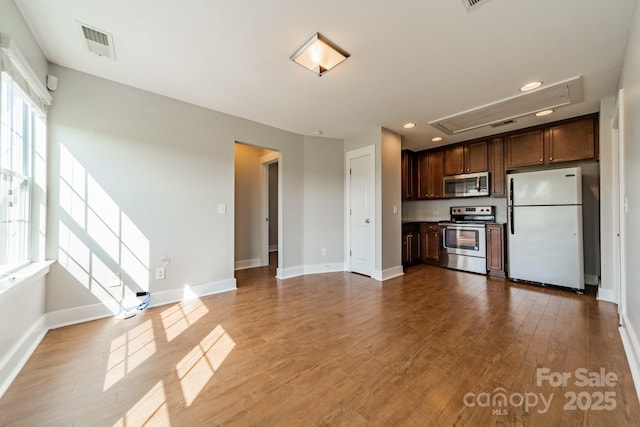 kitchen with dark brown cabinets, light hardwood / wood-style flooring, and stainless steel appliances