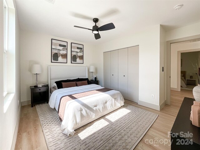 bedroom with ceiling fan, light wood-type flooring, and a closet