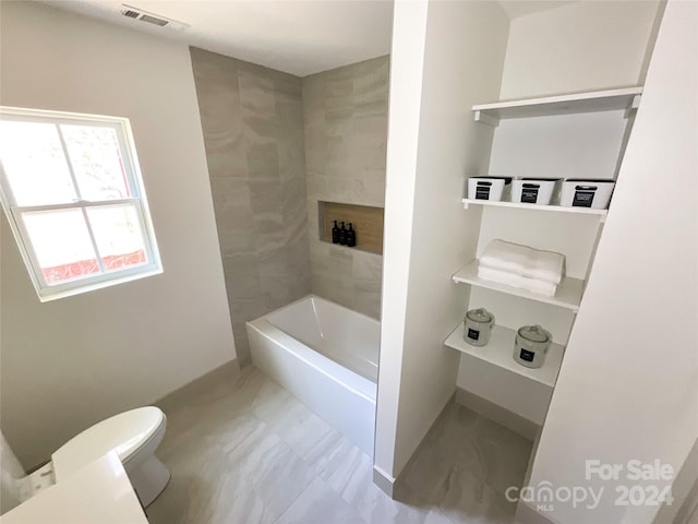 bathroom featuring shower / bathing tub combination and toilet