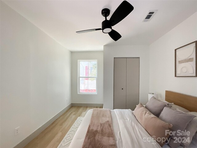 bedroom featuring ceiling fan, a closet, and light hardwood / wood-style flooring