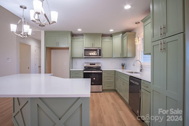 kitchen featuring hanging light fixtures, green cabinets, and appliances with stainless steel finishes