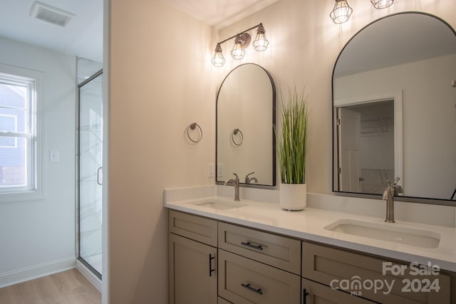 bathroom with a shower with shower door, vanity, and wood-type flooring