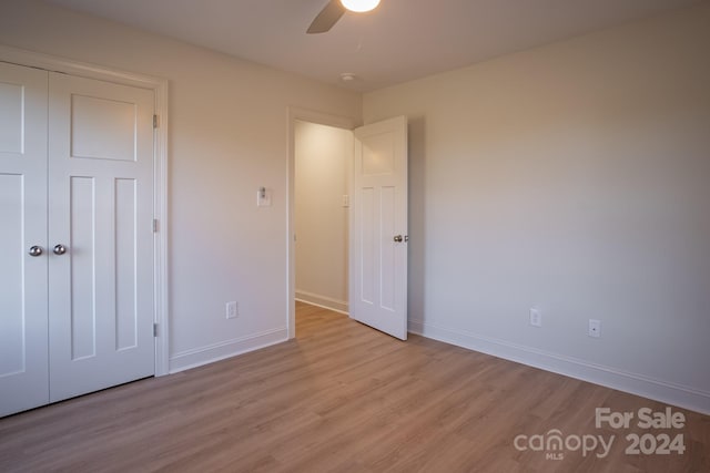 unfurnished bedroom featuring a closet, ceiling fan, and light hardwood / wood-style flooring