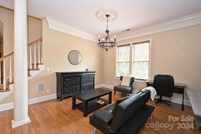 living room featuring ornamental molding, light wood-type flooring, a notable chandelier, and ornate columns