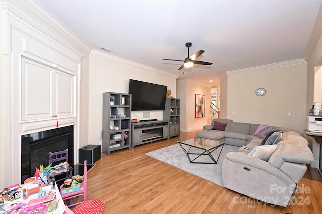 living room featuring ceiling fan, crown molding, and light hardwood / wood-style floors