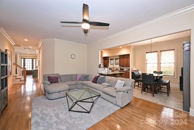 living room with ornamental molding, light hardwood / wood-style floors, and ceiling fan