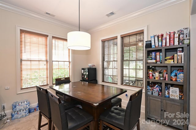 dining space with ornamental molding and light tile patterned floors