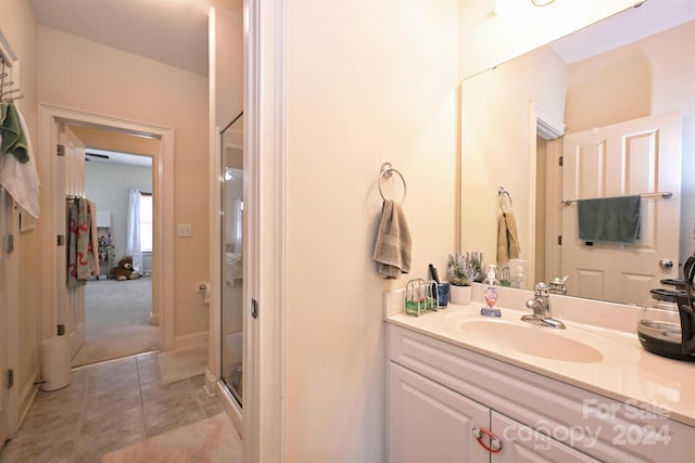 bathroom featuring walk in shower, vanity, and tile patterned floors