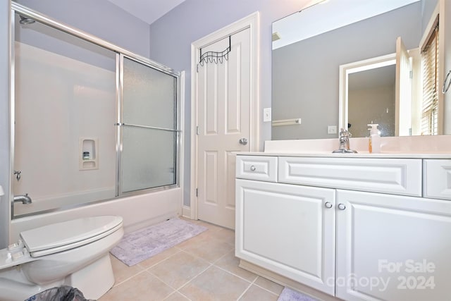 full bathroom featuring shower / bath combination with glass door, vanity, toilet, and tile patterned floors