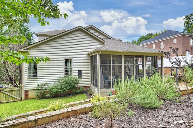 rear view of property featuring a sunroom