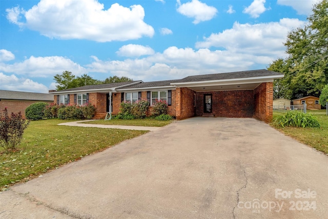 ranch-style house featuring a front lawn and a carport