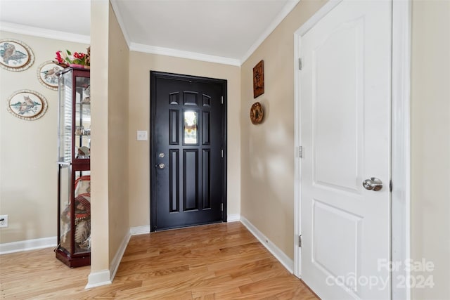 foyer entrance with ornamental molding and light hardwood / wood-style floors