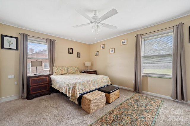 bedroom with multiple windows, ceiling fan, and light carpet