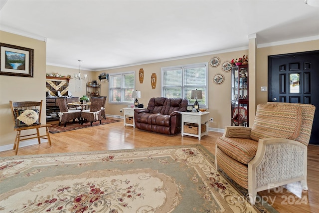 living room with ornamental molding, light wood-type flooring, and an inviting chandelier