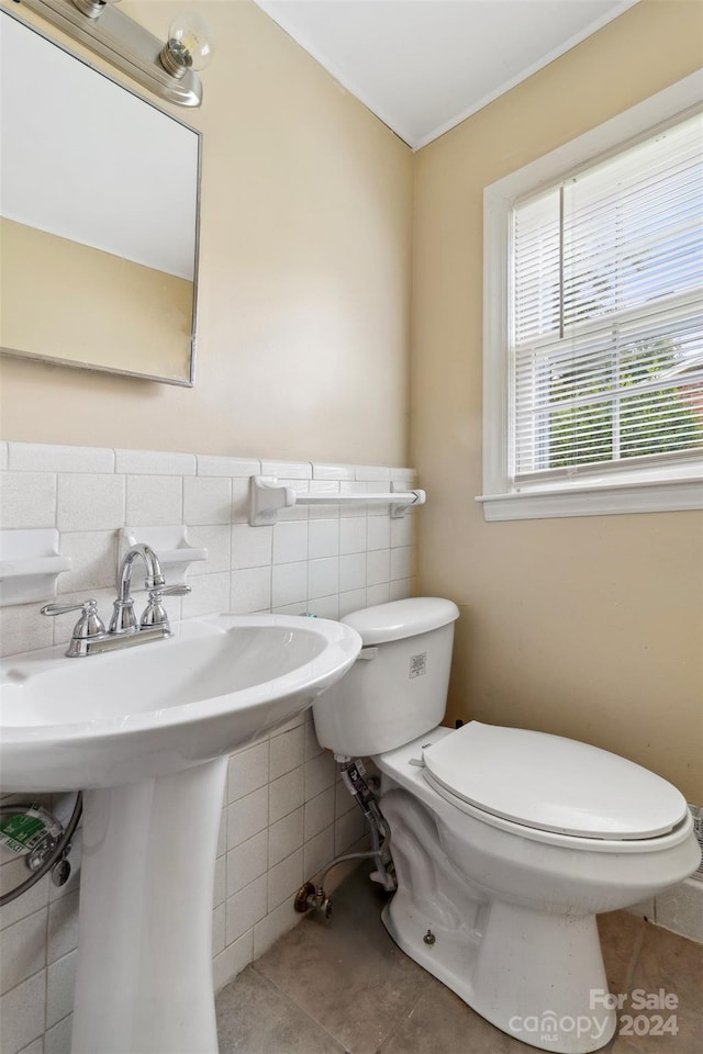 bathroom with tile walls, tile patterned flooring, toilet, and tasteful backsplash