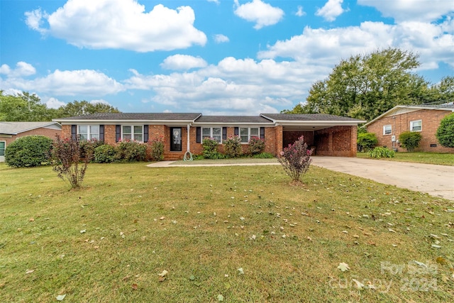 ranch-style home featuring a carport and a front lawn