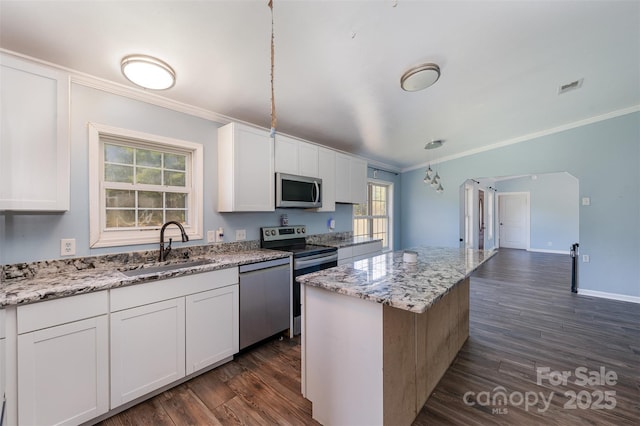 kitchen featuring white cabinets, a kitchen island, and appliances with stainless steel finishes