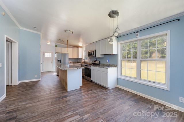 kitchen with hanging light fixtures, appliances with stainless steel finishes, a kitchen island, dark hardwood / wood-style flooring, and white cabinetry