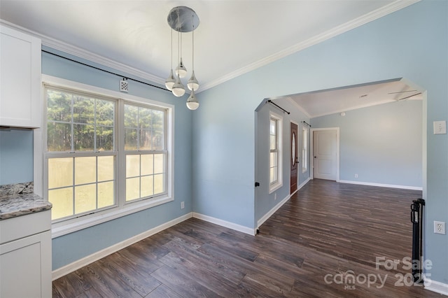 unfurnished dining area featuring ornamental molding, dark wood-type flooring, an inviting chandelier, and lofted ceiling