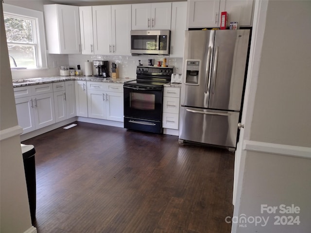 kitchen featuring backsplash, light stone counters, stainless steel appliances, white cabinetry, and dark hardwood / wood-style floors