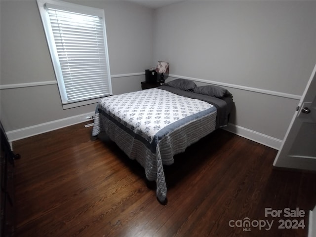 bedroom featuring dark wood-type flooring and multiple windows