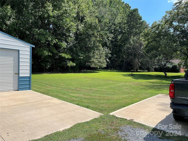 view of yard with a garage and an outdoor structure