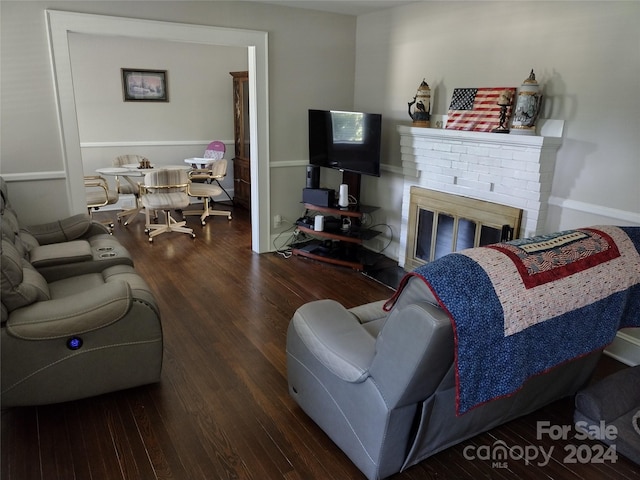 living room with dark wood-type flooring and a fireplace